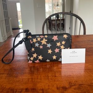 Brand new! Coach wallet/wristlet. Black with colorful stars on it.